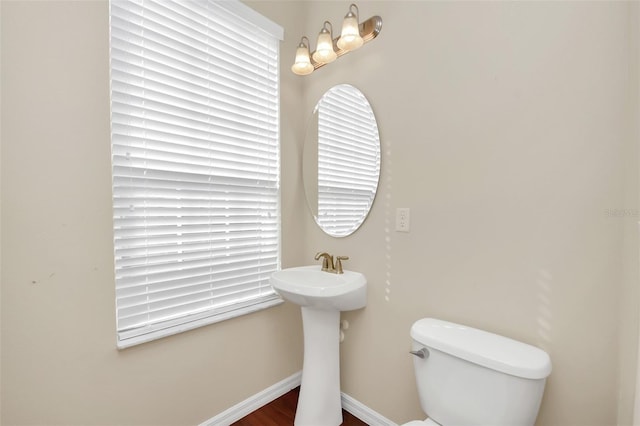 half bath with toilet and baseboards
