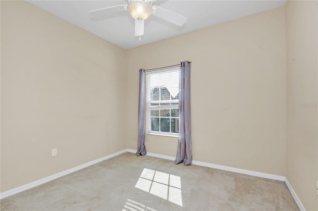 empty room with a ceiling fan, baseboards, and light colored carpet