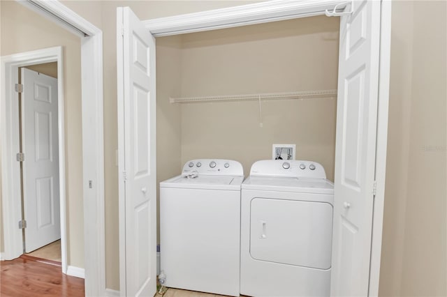 laundry area featuring wood-type flooring and washing machine and dryer