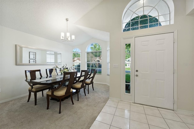 carpeted foyer with lofted ceiling, a textured ceiling, and an inviting chandelier