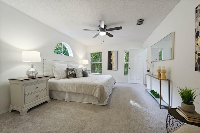 bedroom with a textured ceiling, light carpet, and ceiling fan