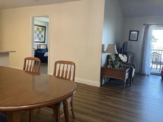 dining area featuring lofted ceiling and dark hardwood / wood-style flooring