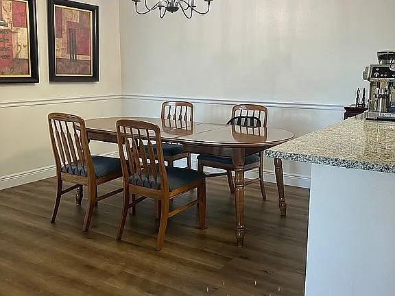 dining space with dark hardwood / wood-style floors and a notable chandelier