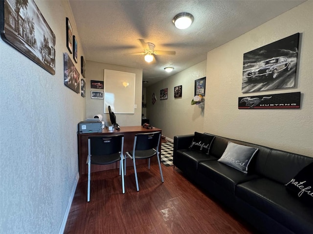 office area with a textured ceiling, dark wood-type flooring, and ceiling fan