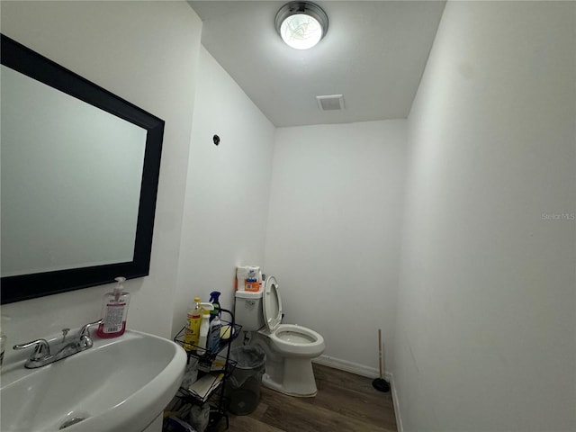 bathroom featuring toilet, hardwood / wood-style floors, and sink