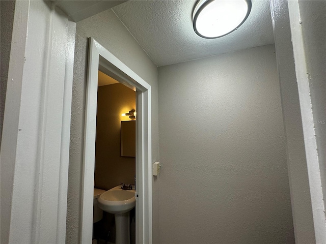 bathroom with a textured ceiling and sink