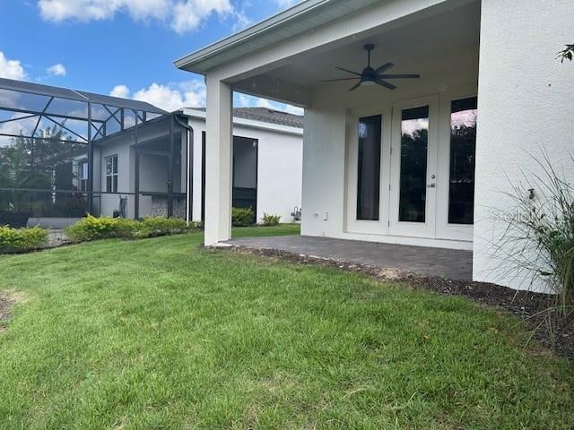 back of house with a patio, ceiling fan, a lanai, and a lawn