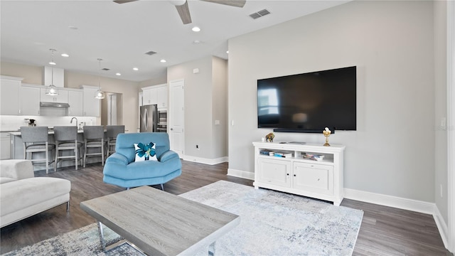 living room with ceiling fan and dark hardwood / wood-style floors