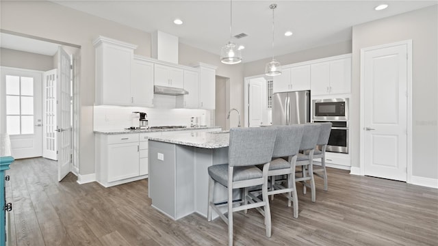 kitchen featuring white cabinetry, an island with sink, dark wood-type flooring, and appliances with stainless steel finishes