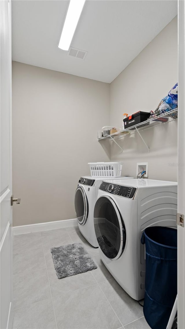 washroom with light tile patterned flooring and washing machine and dryer