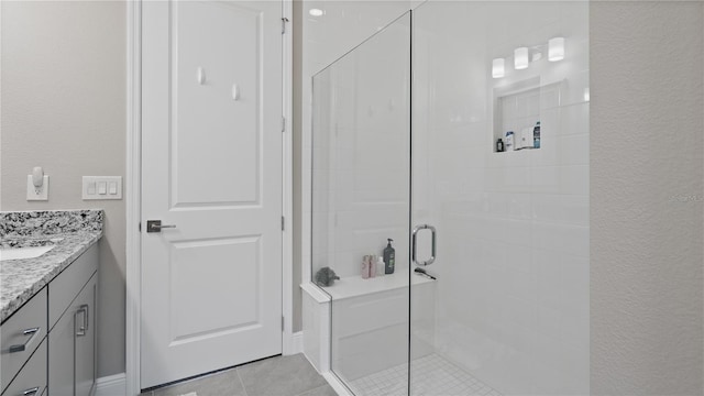 bathroom with tile patterned flooring, vanity, and a shower with shower door