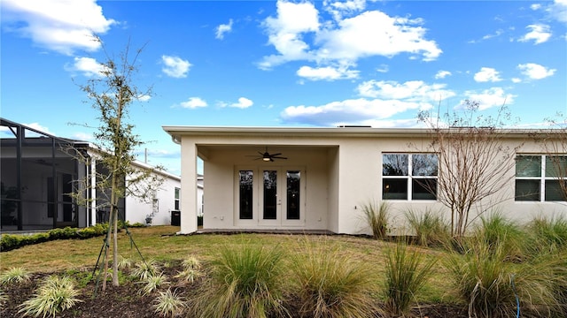 back of house featuring a lawn, ceiling fan, and a lanai