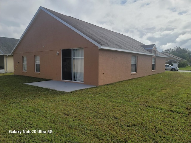 back of house with a patio and a lawn