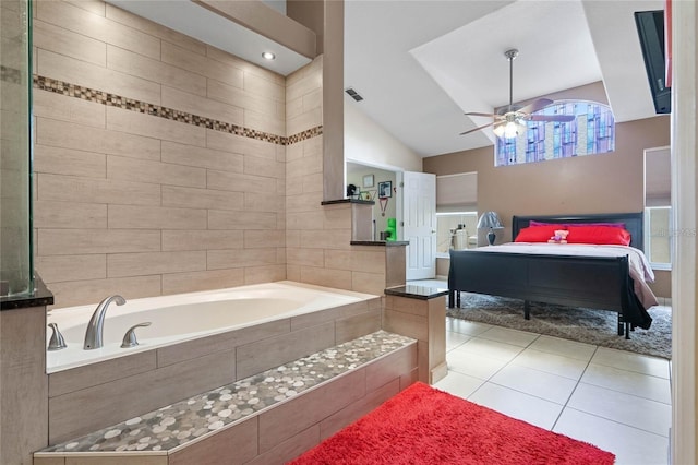 bathroom with tile patterned floors, vaulted ceiling, tiled bath, and ceiling fan