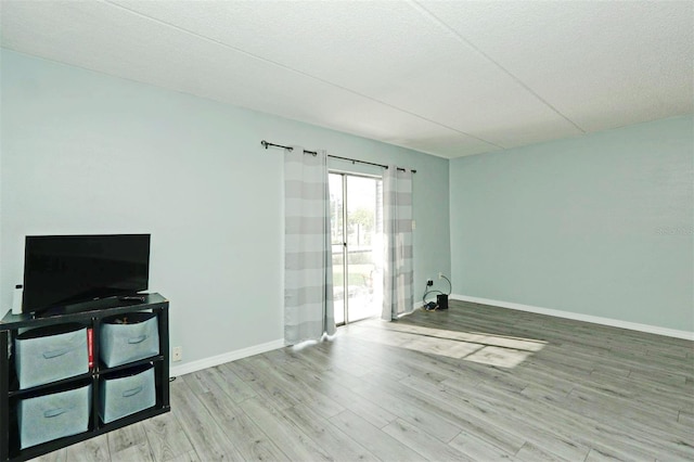 interior space featuring light wood-type flooring and a textured ceiling