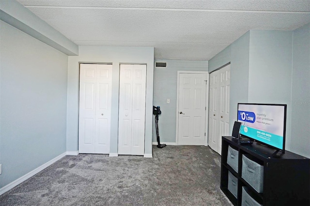 bedroom with multiple closets, baseboards, carpet flooring, and visible vents