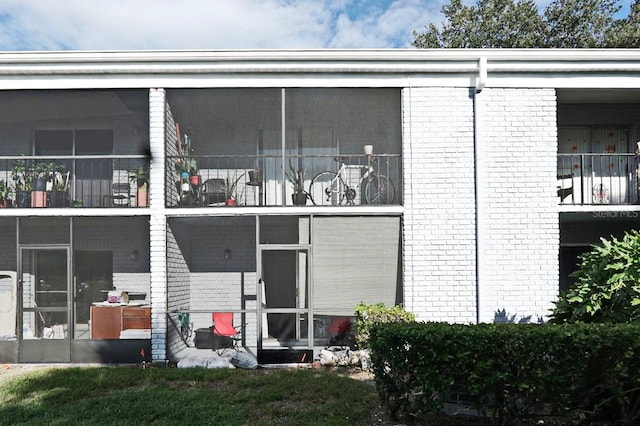 back of house with a balcony and a sunroom