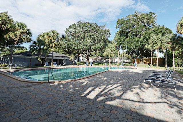 community pool featuring fence and a patio area