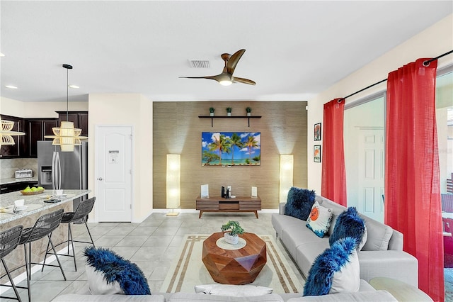 living room with ceiling fan and light tile patterned floors