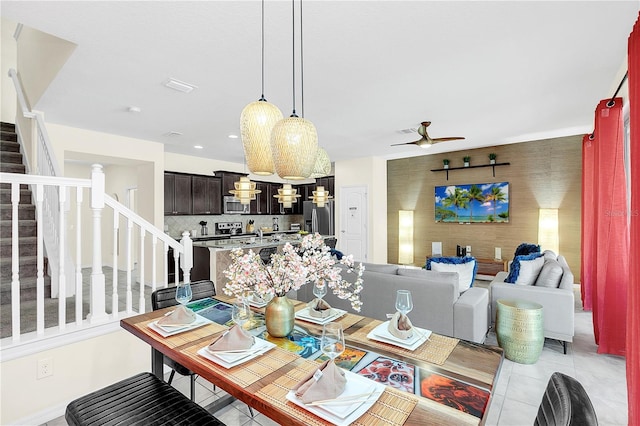 dining room featuring ceiling fan with notable chandelier and light tile patterned floors