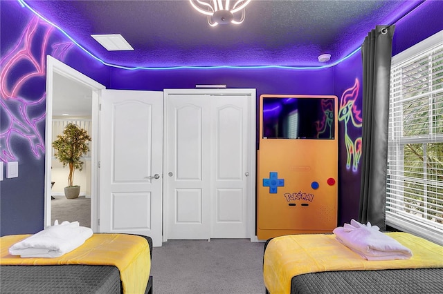 carpeted bedroom featuring a closet and a textured ceiling