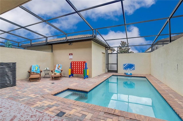 view of pool with a patio and glass enclosure