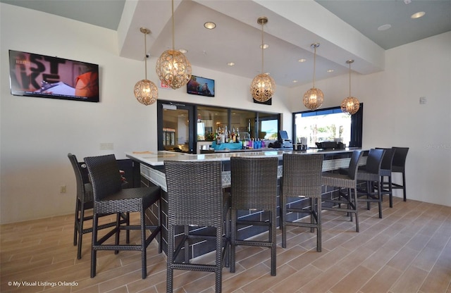 bar featuring pendant lighting and light hardwood / wood-style flooring