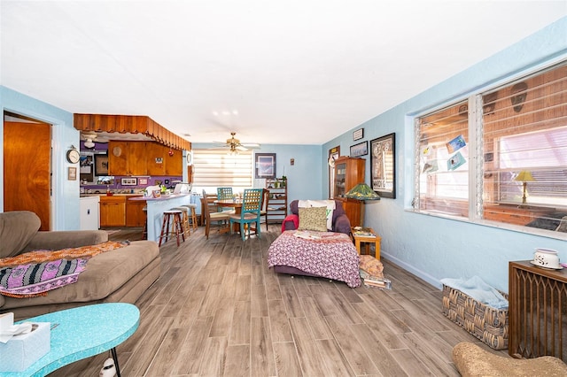 living room featuring light hardwood / wood-style floors and ceiling fan