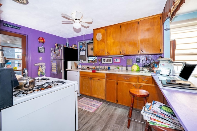 kitchen with ceiling fan, sink, white appliances, tasteful backsplash, and light hardwood / wood-style flooring