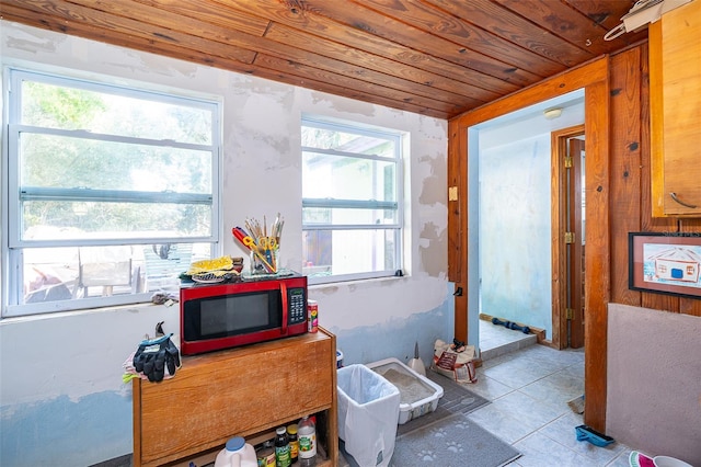 interior space featuring light tile patterned floors and wooden ceiling