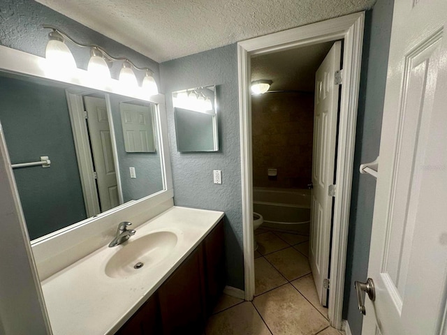 full bathroom featuring tile patterned flooring, a textured ceiling, vanity, tiled shower / bath, and toilet