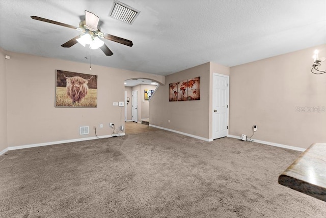 unfurnished living room with ceiling fan, carpet floors, and a textured ceiling