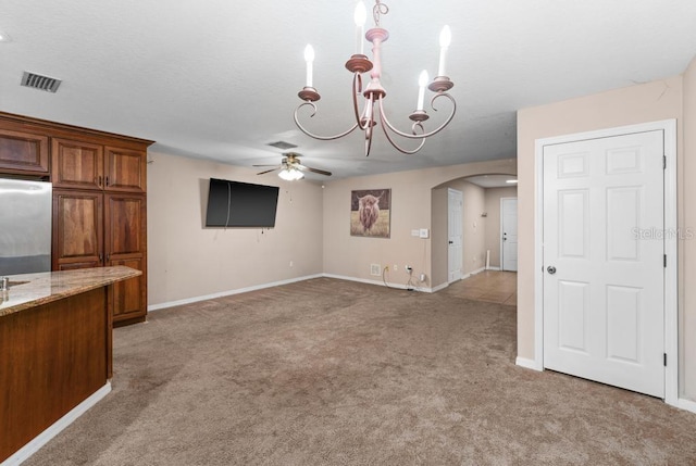 interior space featuring ceiling fan with notable chandelier and carpet