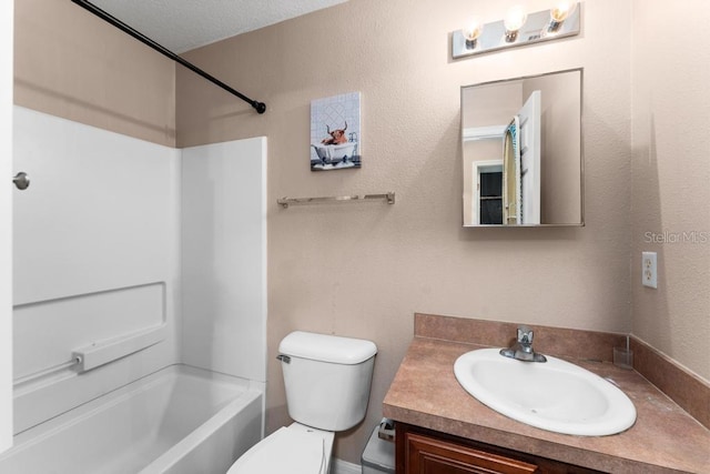 full bathroom featuring a textured ceiling, shower / washtub combination, vanity, and toilet