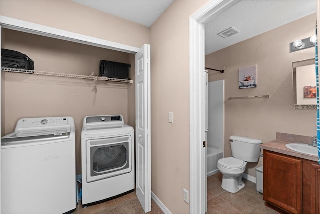 washroom featuring light tile patterned flooring, sink, and independent washer and dryer