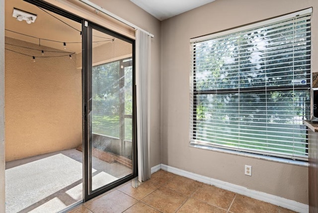 doorway with light tile patterned floors and a wealth of natural light