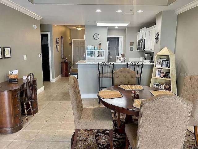 tiled dining area featuring crown molding