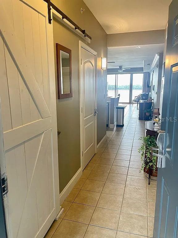 hall featuring light tile patterned flooring and a barn door