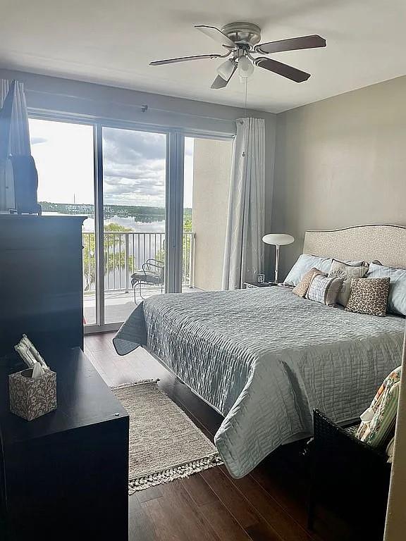 bedroom with ceiling fan, wood-type flooring, and multiple windows