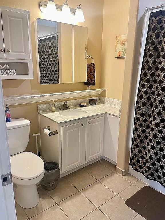 bathroom featuring tile patterned floors, vanity, and toilet