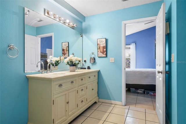 bathroom with a textured ceiling, tile patterned floors, and vanity