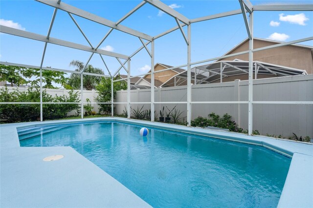 view of pool featuring glass enclosure