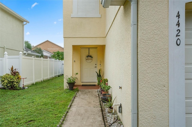 property entrance with a lawn