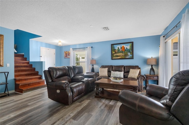 living room with dark wood-type flooring and a textured ceiling