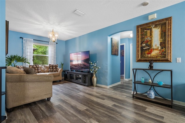 living room with wood-type flooring, a textured ceiling, and a chandelier