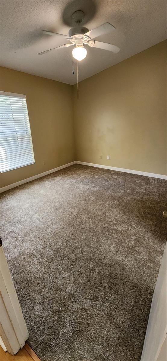 carpeted spare room with a textured ceiling and ceiling fan