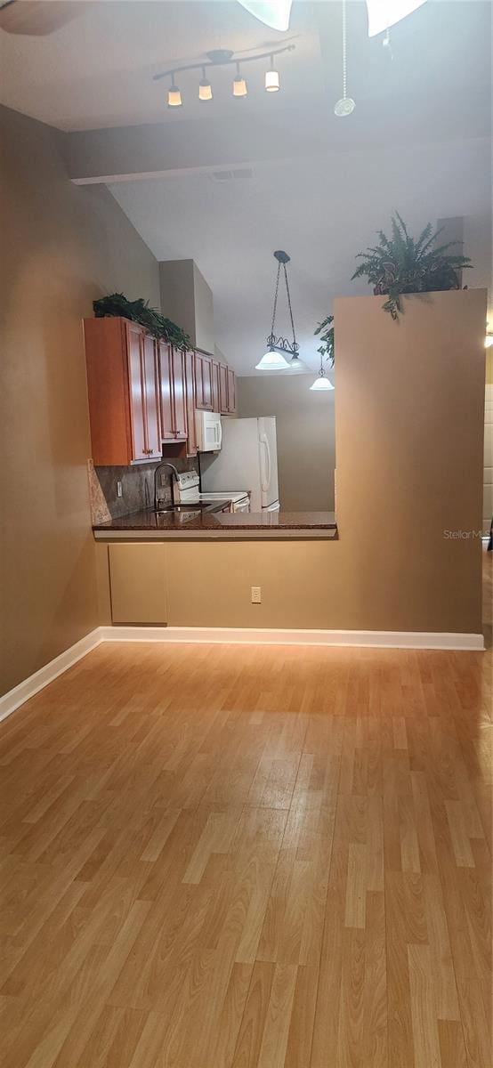 kitchen featuring white appliances, pendant lighting, light hardwood / wood-style floors, and kitchen peninsula