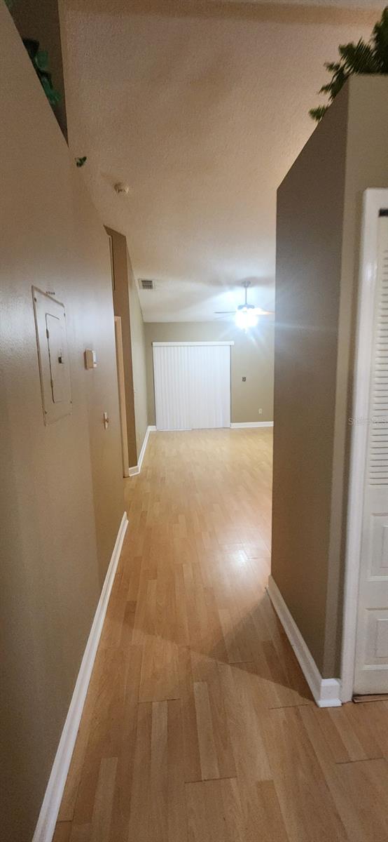 hall with electric panel and light hardwood / wood-style flooring