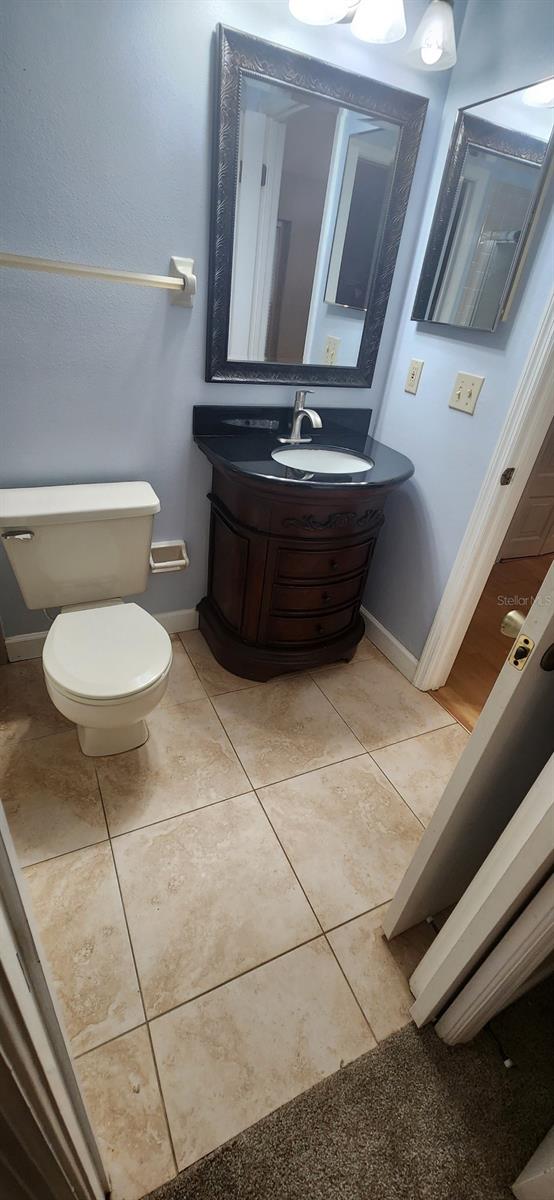 bathroom featuring vanity, toilet, and tile patterned flooring