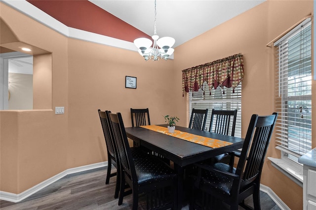 dining area featuring a chandelier, vaulted ceiling, and dark wood-type flooring